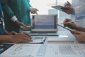 Multiracial team of doctors discussing a patient standing grouped in the foyer looking at a tablet computer, close up view Royalty Free Stock Photo