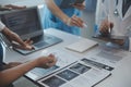 Multiracial team of doctors discussing a patient standing grouped in the foyer looking at a tablet computer, close up view Royalty Free Stock Photo