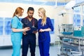 Multiracial team of doctors discussing a patient standing in a operating room Royalty Free Stock Photo