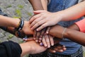 Multiracial teen friends joining hands together in cooperation
