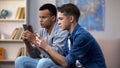 Multiracial teenagers playing games on smartphones, ignoring live communication