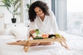 Multiracial woman wearing white robe holding bottle with skin moisturizing tonic Royalty Free Stock Photo