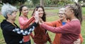 Multiracial women stacking hands outdoor at city park - Main focus on center senior woman face Royalty Free Stock Photo