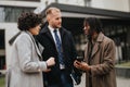 Multiracial young business partners discussing work outside office building. Royalty Free Stock Photo
