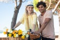 multiracial young couple with bicycle with flowers in basket