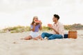 Multiracial young couple eating watermelon during picnic on beach Royalty Free Stock Photo