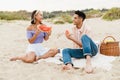 Multiracial young couple eating watermelon during picnic on beach Royalty Free Stock Photo