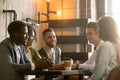 Multiracial young friends talking and drinking coffee sharing co Royalty Free Stock Photo