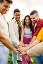 Multiracial young happy friends stacking hands at city park Royalty Free Stock Photo