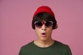Multiracial young man, teenager 17s posing wearing Great Britain sunglasses print, red hat, khaki t-shirt isolated on Royalty Free Stock Photo