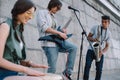 Multiracial young musical band with guitar drum and saxophone performing