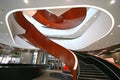 Multistory indoor atrium with suspended wood spiral stairs like dancing ribbon at University of Sydney Business School, Australia