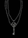 A multistrand black pearls necklace with a skeleton key motif. Gothic art. AI generation Royalty Free Stock Photo
