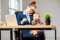 Multitasking businesswoman with her son working at the office Royalty Free Stock Photo