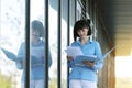 Multitasking busy young business woman during walks reading and dropping important finance documents by the office Royalty Free Stock Photo