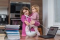 Multitasking mother is babysitting and working at home Royalty Free Stock Photo