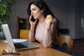 Multitasking businesswoman hold rubber expander tool in hand talking on mobile phone at workplace Royalty Free Stock Photo