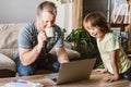 A multitasking young father tries to work from home with his son. A man checks his mail on a laptop and drinks coffee Royalty Free Stock Photo