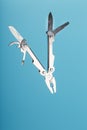 The multitool multi-function tool hovers on a blue background. The concept of an expanded multi-tool with free space