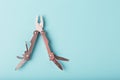 The multitool multi-function tool hovers on a blue background. The concept of an expanded multi-tool with free space