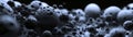 A multitude of pock-marked grey spheres on an ultra-wide background