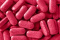 Multivitamin everyday pills toned viva magenta color. Heap of daily herbal tablets close-up texture. Medical dietary supplements