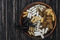 Multivitamin pills on a clay plate, on a vintage wooden table