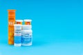 Multivitamin tablets and Vitamin C container closeup on blue background Royalty Free Stock Photo