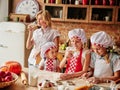 Mum with children in kitchen drinking milk. Cooking girls