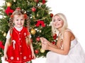 Mum with a daughter decorate christmas tree.