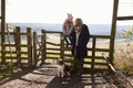 Mum and daughter by rural gate with dog look at each other Royalty Free Stock Photo