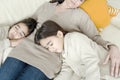 Mum and daughters sleeping on couch