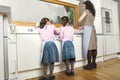 Mum and Daughters Washing Up In Kitchen Royalty Free Stock Photo