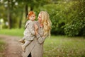 Mum gently embraces the redhead baby girl on autumn forest background Royalty Free Stock Photo