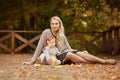 Mum gently embraces the redhead baby girl on autumn forest background Royalty Free Stock Photo