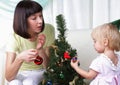 Mum and her daughter decorate a christmas fur-tree Royalty Free Stock Photo