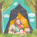 Mum and her kids reading book in a tepee tent in garden