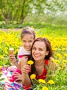 Mum and kid girl child among yellow flowers dandelions Royalty Free Stock Photo