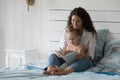 Mum and little daughter read book together in bed Royalty Free Stock Photo