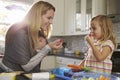 Mum and older daughter eating fruit, while baby sleeps in baby carrier Royalty Free Stock Photo