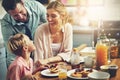 Mum says the most important meal cant wait. a little boy eating breakfast with his parents.