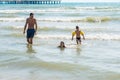 Mum, son and dad splashong and swimming in sea waves. Boy in water wings. Royalty Free Stock Photo