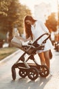Woman in a white dress with child carriage Royalty Free Stock Photo