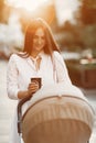 Woman in a white dress with child carriage Royalty Free Stock Photo