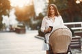 Woman in a white dress with child carriage Royalty Free Stock Photo