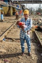 Indian young boy holds a child in his arms on railroad near Suburban Railway in Dharavi Slum at Mumbai. India Royalty Free Stock Photo