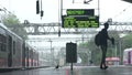 A young boy walking with umbrella on platform of railway station at Mumbai, India.