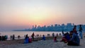 Mumbai , Maharashtra, India on May 20 th 2019 : People sitting at Girgaum Chowpatty With Mumbai's Skyline behind and sunset