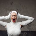 Mummy girl scream in shock. Portrait of a young beautiful woman in bandages all over her body. Royalty Free Stock Photo