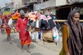 Brightly dressed religious pilgrims walk alongside the road in rural India.